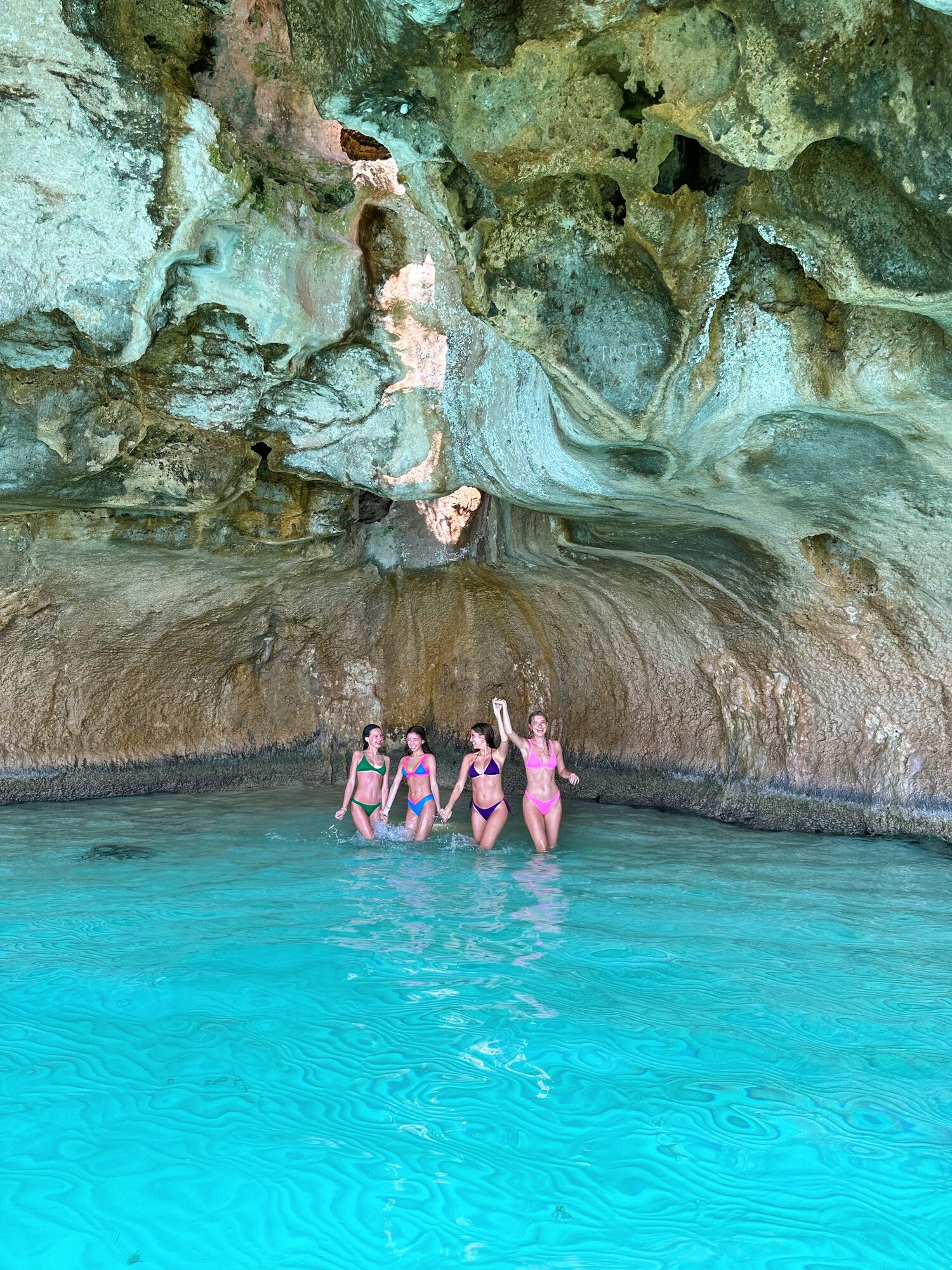 Four friends swimming in Thunderball Grotto's turquoise waters