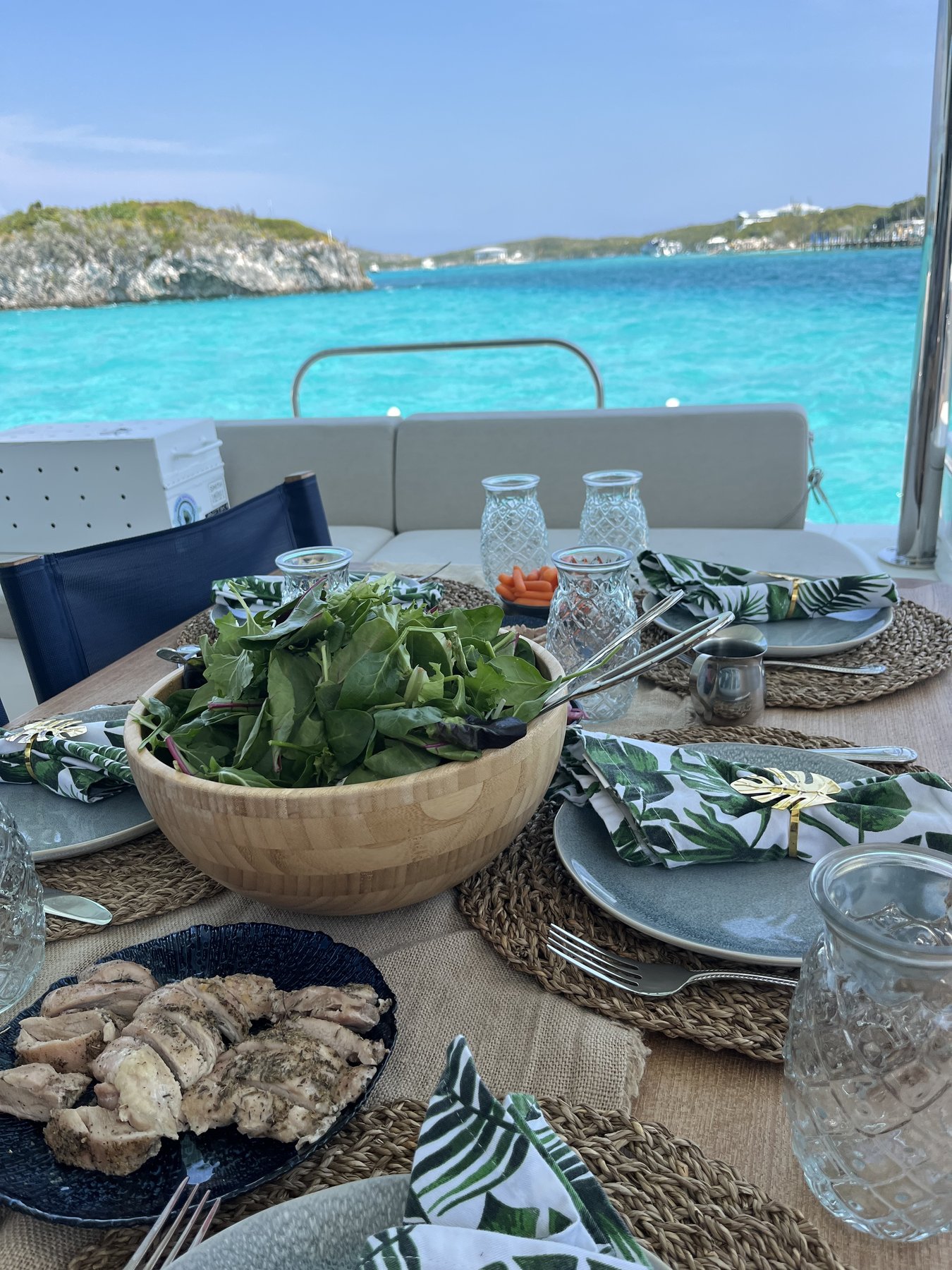 Lunch set in PurelyBlu's cockpit with turquoise Exumas water and a cay behind