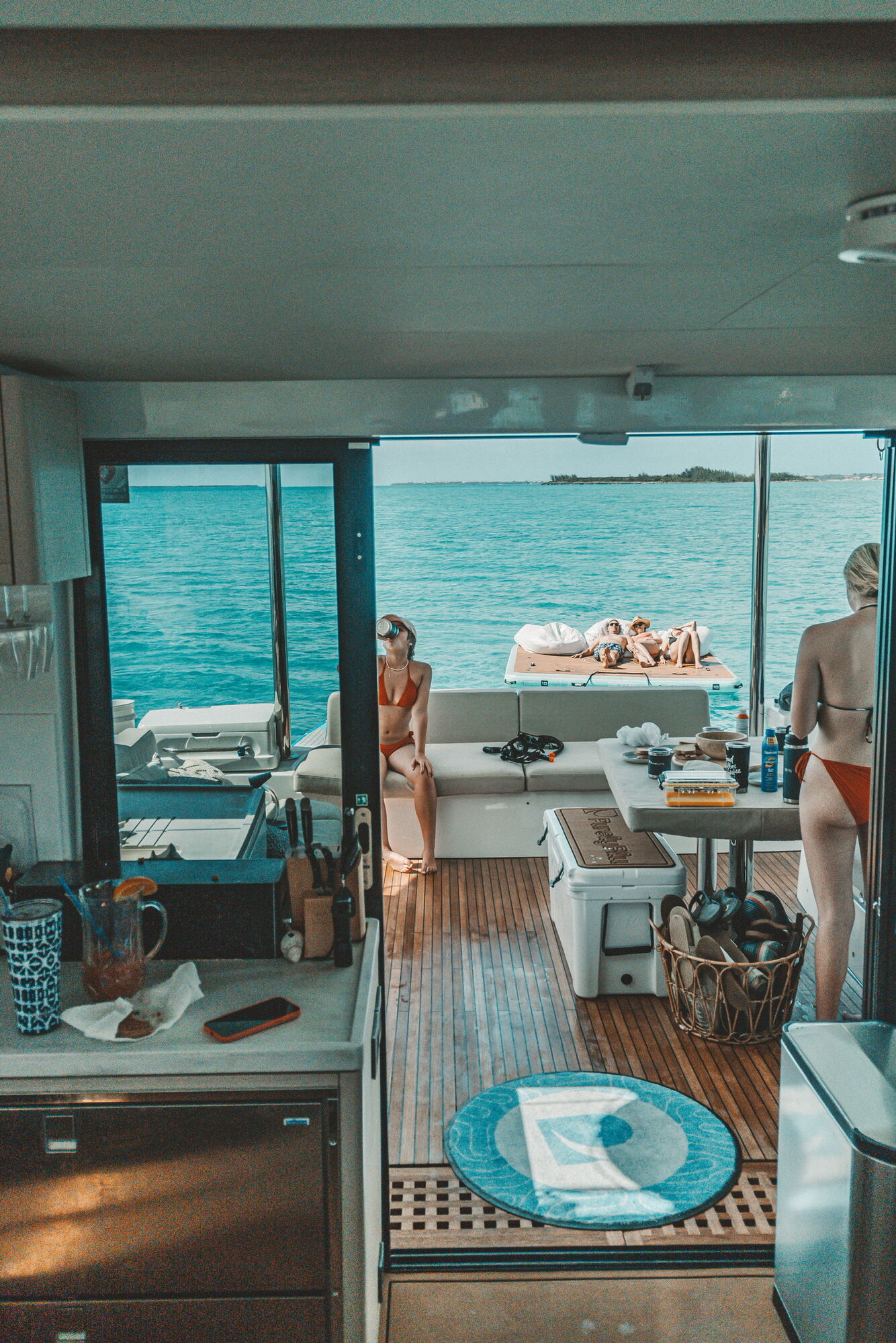 View from PurelyBlu galley through cockpit to floating platform on turquoise water